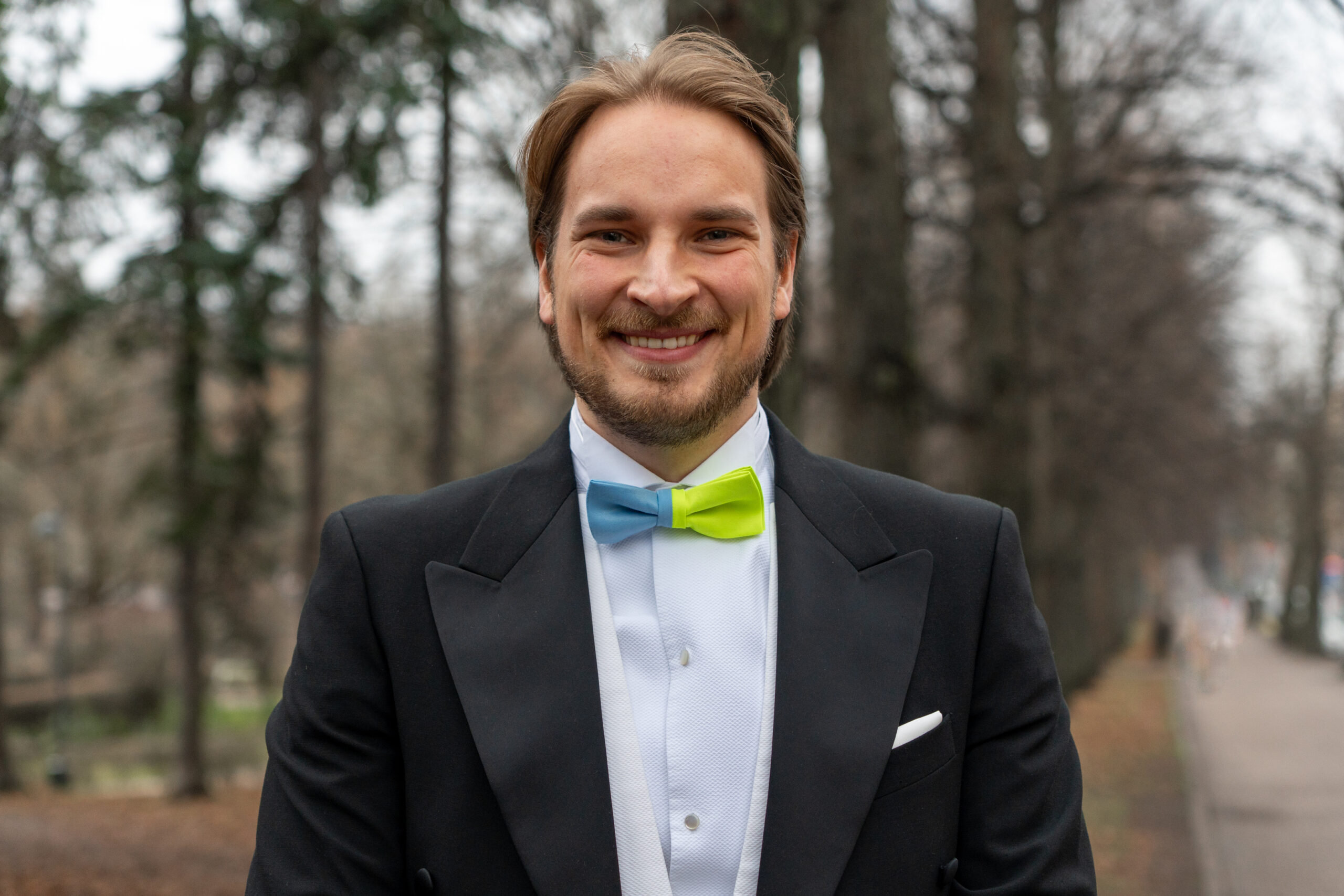 Anselmi Auramo frakissa ja kaksivärisessä haalareista valmistetussa rusetissa